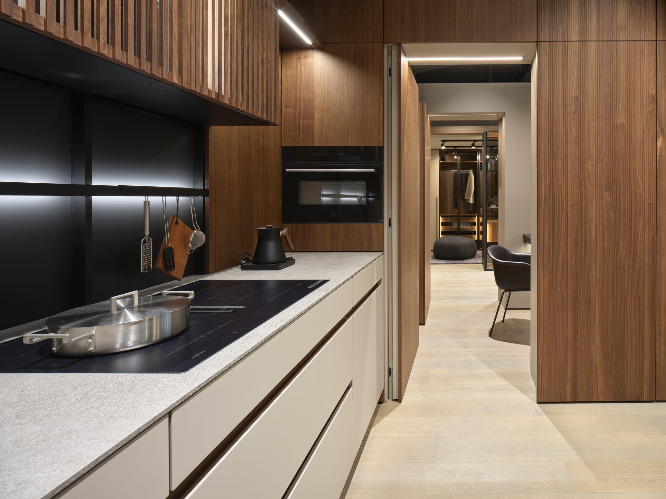 Galley kitchen in walnut and pale lacquer leading to a dressing room