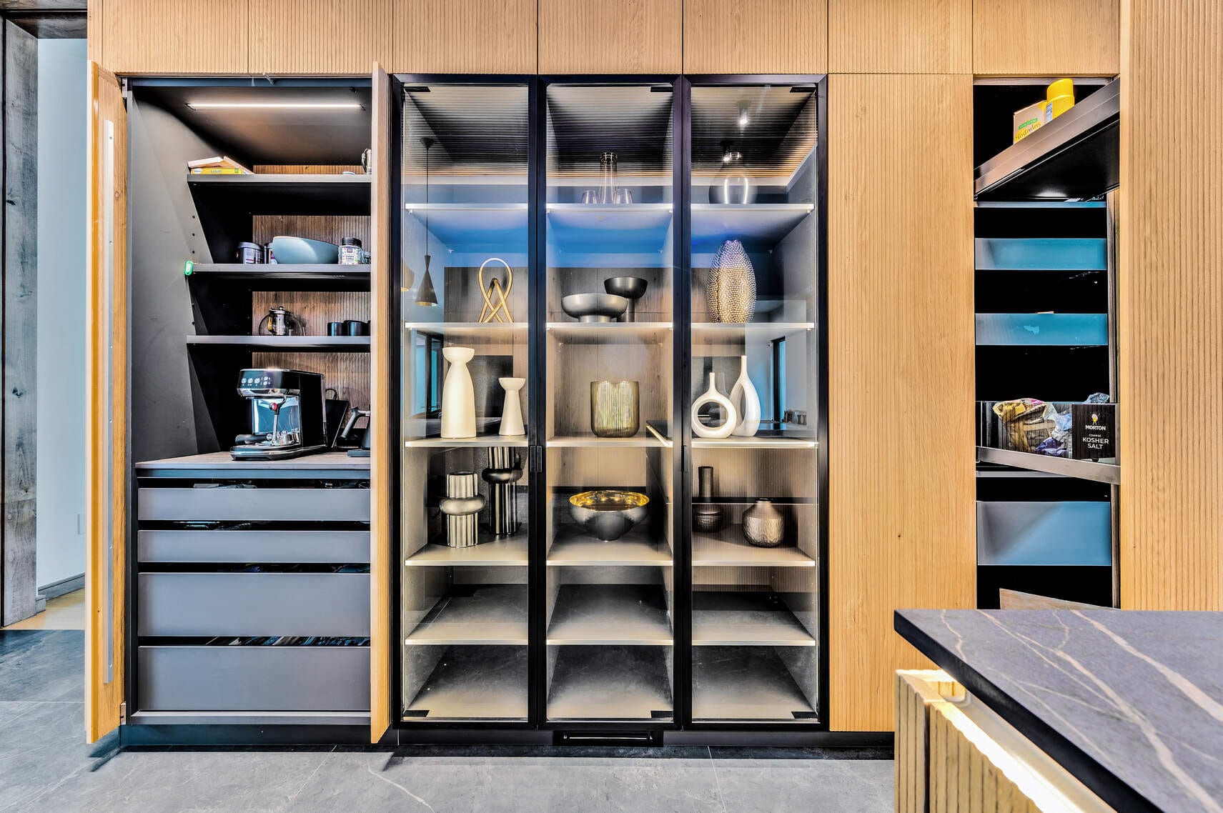 Lit pantry cabinet with glass shelves and pull-outs