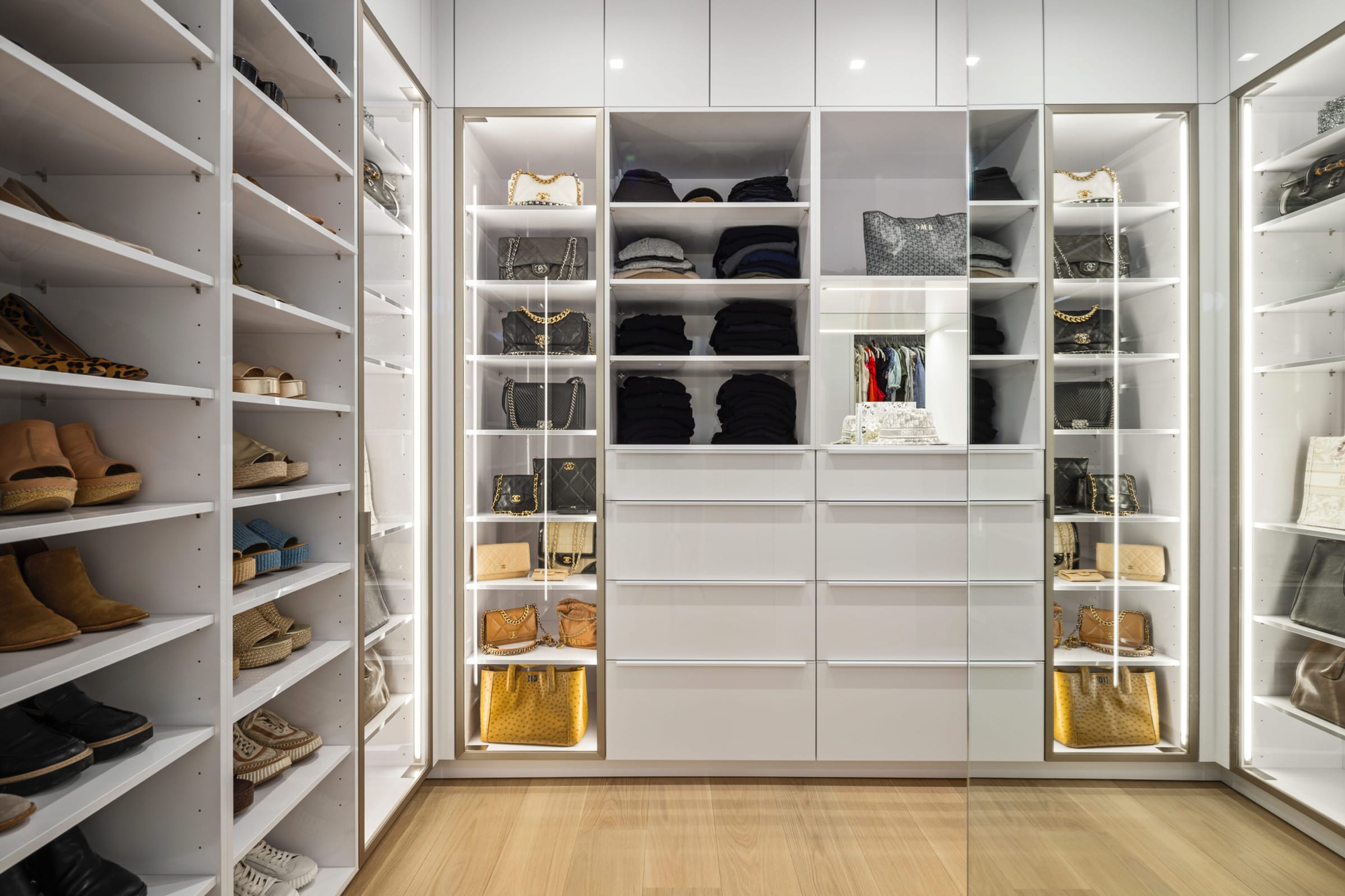 White high-gloss walk-in closet with glass doors, Purchase NY
