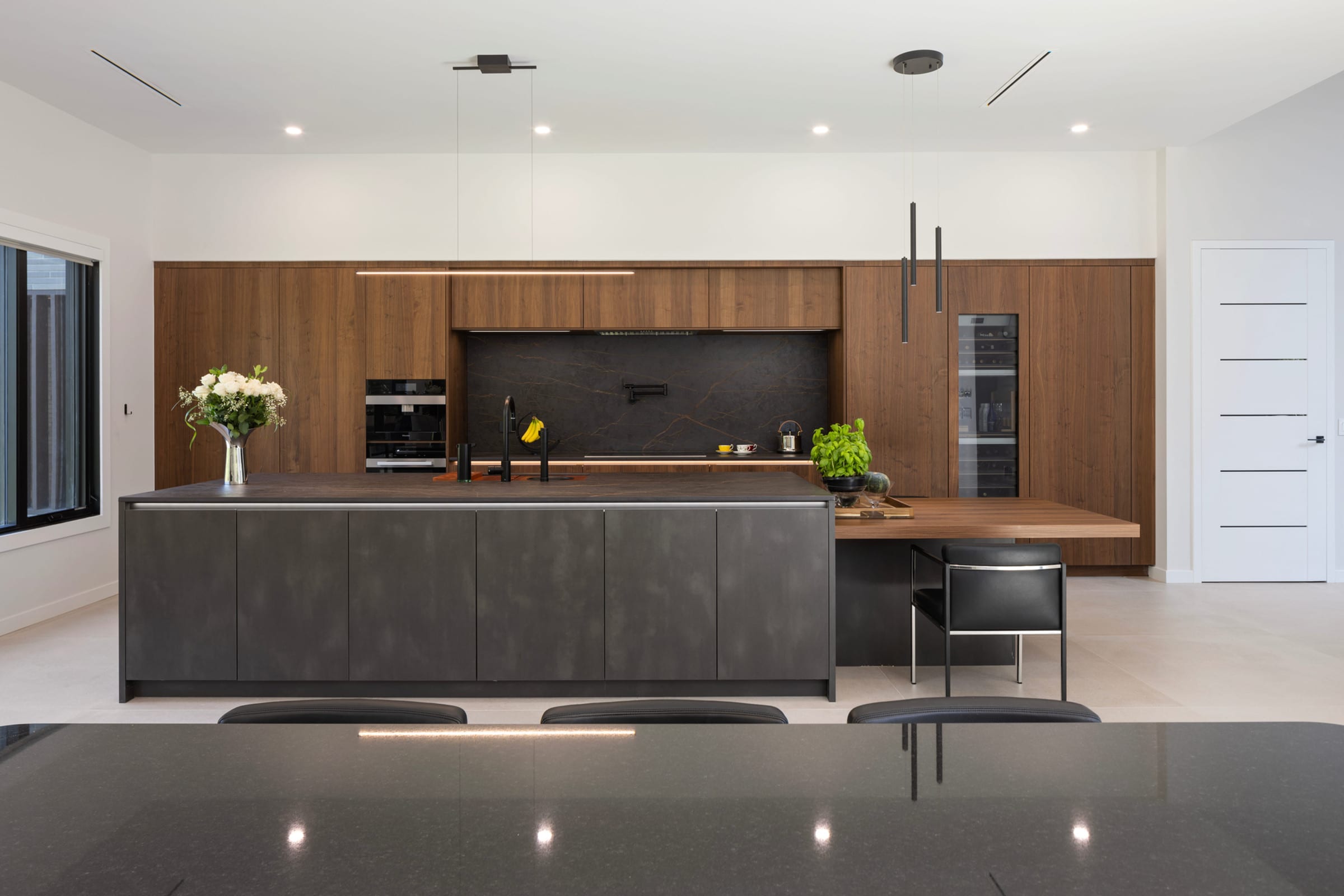Dark walnut handleless kitchen with stone island