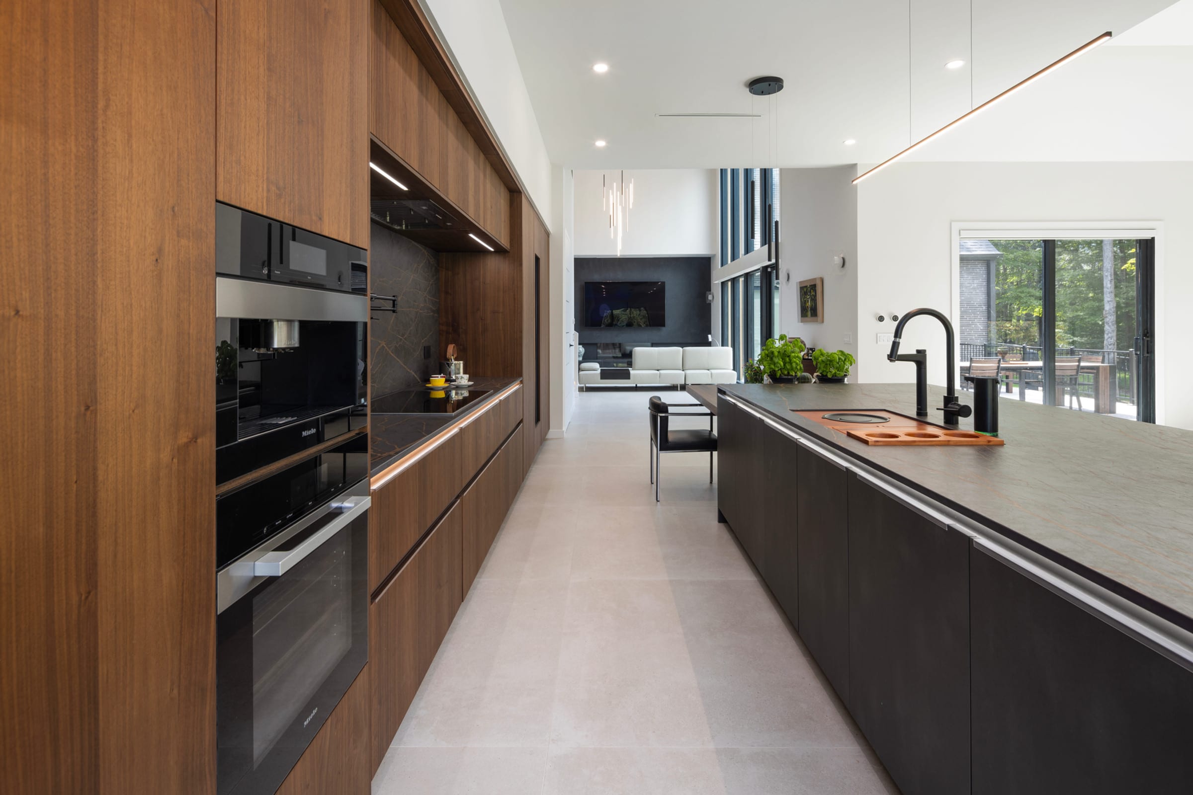 Walnut galley with dark island and integrated ovens