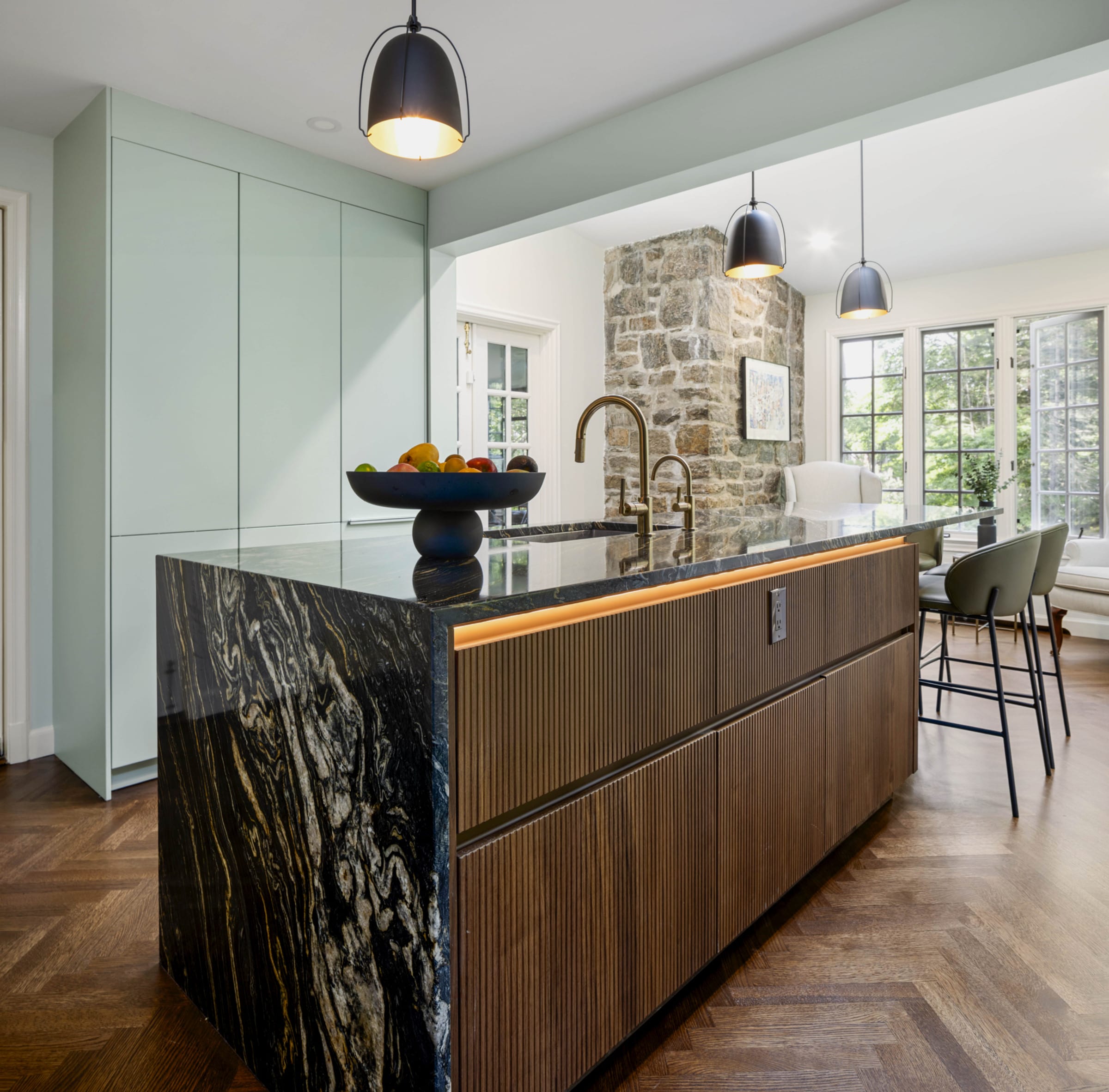 Jade green and walnut kitchen beside a stone wall