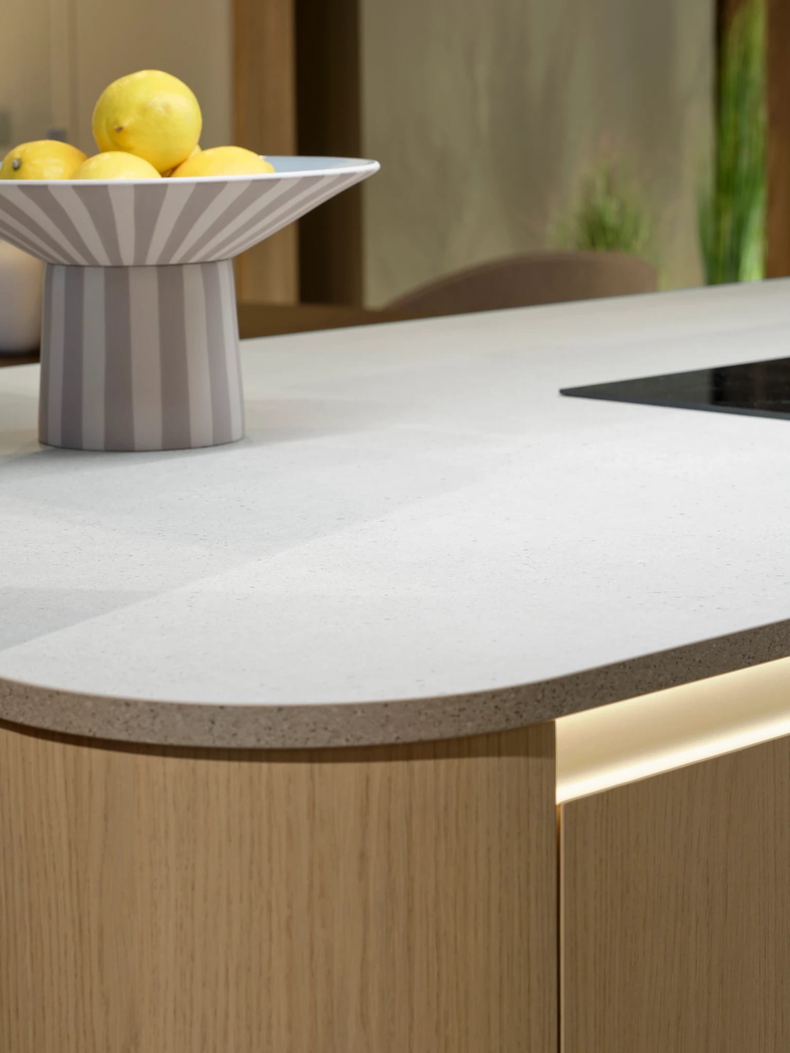Close detail of a curved stone worktop over oak with a light line