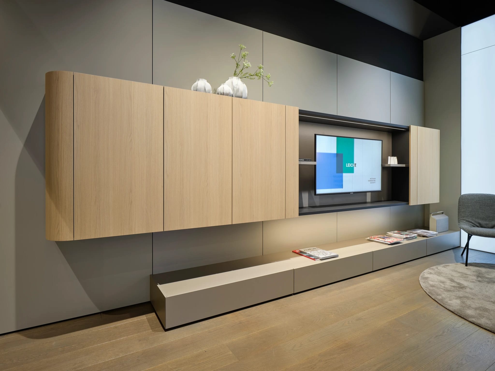 Living room wall in oak with floating cabinets and a low media bench