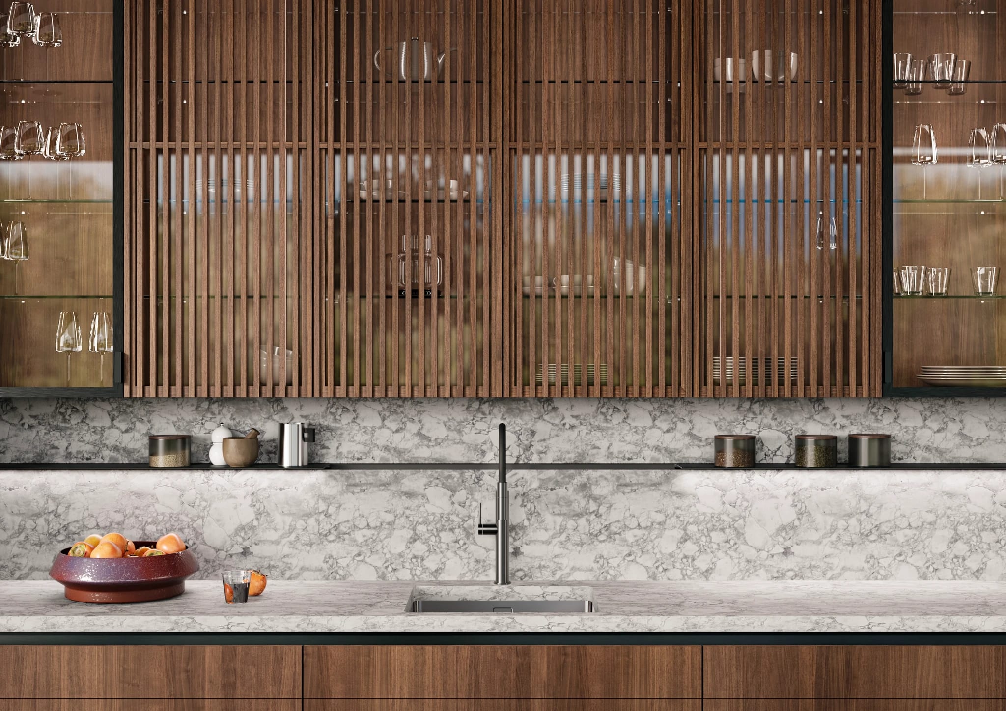 Wall of fluted walnut and glass cabinets above a marble backsplash